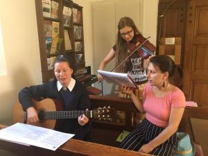 Marienschwester und junge Frauen singen und spielen Instrumente im Heiligtum